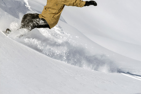 Freerider snowboarder moving down in snow powderの写真素材