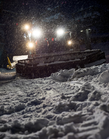 Snowcat preparing a slope at night in high mountains at skiing resort of the North Caucasus Elbrusの写真素材