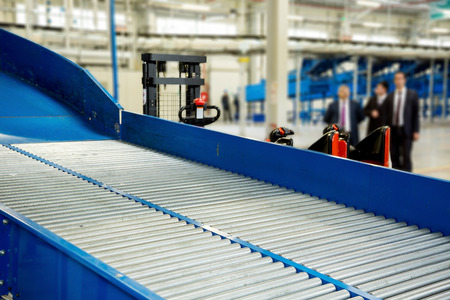 Sorting line with roller conveyor system for transporting crates in large modern warehouse with forkliftsの写真素材
