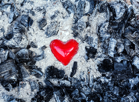 Love symbol red heart on the background of the coal and ashesの写真素材