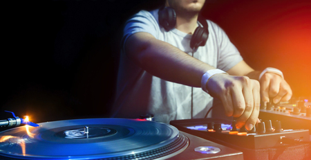 Dj mixes the track in the nightclub at party. Vinyl Player in foregroundの写真素材