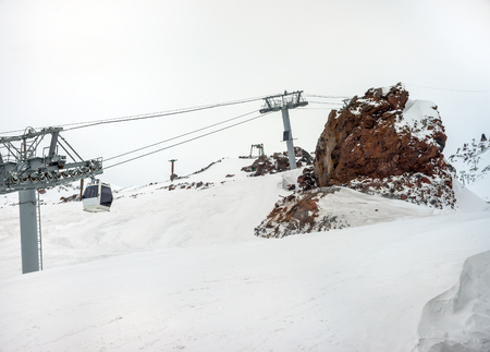 Cableway in motion on rise and descent on ski resort on background beautiful landscape of snowy high mountains Caucasus Elbrusの写真素材