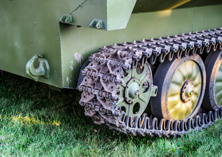 Crawler tracks of military tank and steel wheels of green color, military industry, modern army, side view close up detailの写真素材