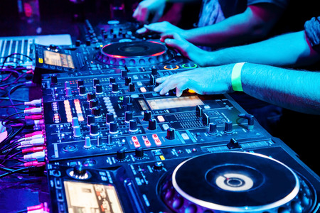 Dj mixes the track in nightclub at party. Body part on the DJ's music control panelの写真素材