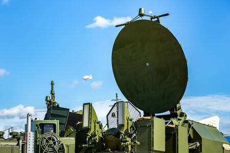 Military radar radio locator station, parabolic antenna on  blue skyの写真素材