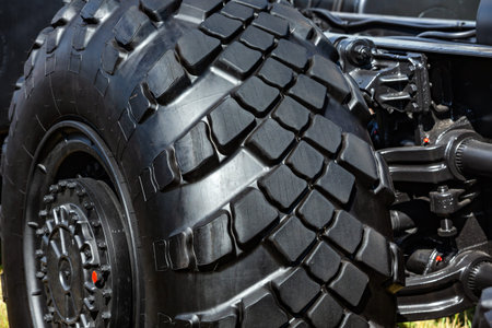 Wheel heavy military transport with the disc and a black rubber tire tread closeup