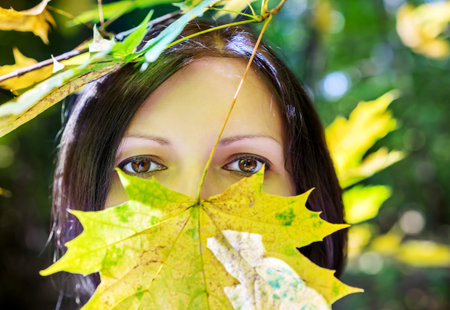 Portrait of young beautiful woman, enjoying walking at scenic autumn park under the tree in the...