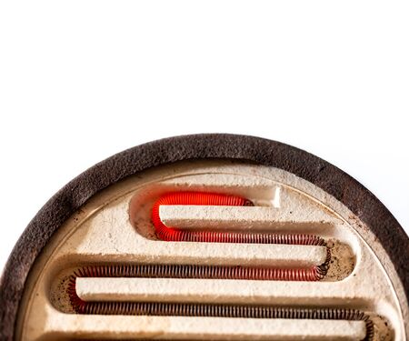 Old rusty electric stove with an incandescent spiral closeup isolated on whiteの写真素材