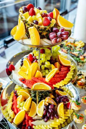 Buffet of ripe fruits on plate close up on festive day at the eventの写真素材
