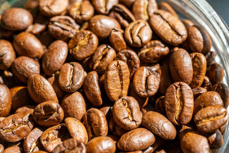 Roasted coffee beans in a glass jar closeup. Morning sunlightの写真素材