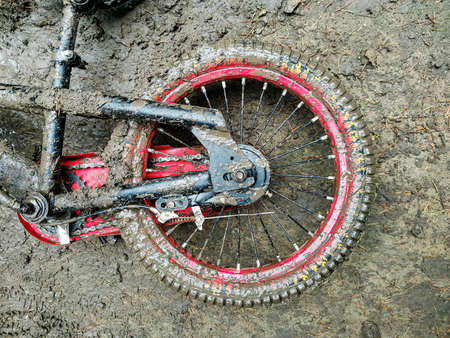 Children's bicycle, covered with dirt, abandoned on the streetの写真素材