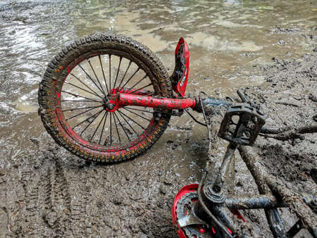Children's bicycle, covered with dirt, abandoned on the streetの写真素材