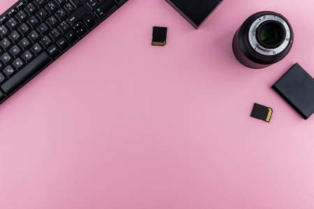 Minimal backdrop concept. Flay lay photography. Pink trendy color. Office tools, keyboard and drives.の写真素材