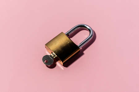 Minimal flatlay concept on pink backdrop. Single lock with key.の写真素材