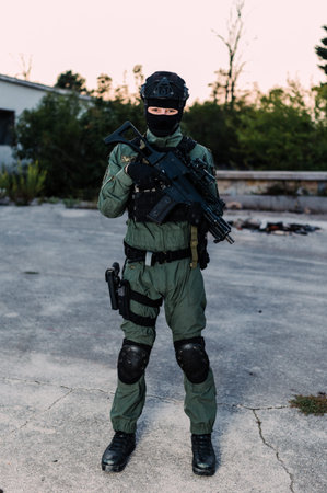 Man reenacting special unit of Croatian military police. Wearing green jumpsuit with black add-ons and assault rifle G36.の写真素材