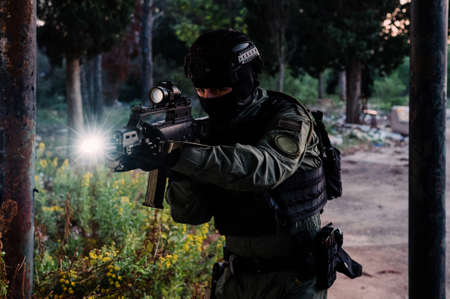 Man reenacting special unit of Croatian military police. Wearing green jumpsuit with black add-ons and assault rifle G36.の写真素材