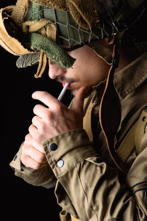 World War II, American 101 Airborne soldier wearing a m42 uniform and lightening cigarette. (506pri). E company, D-day invasion 44.の写真素材
