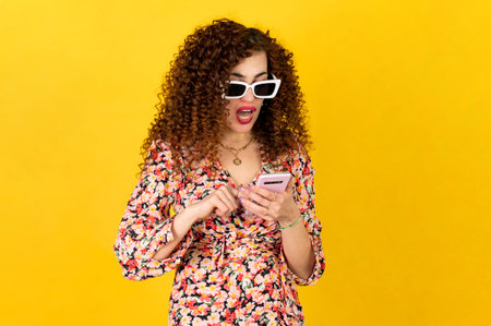 Girl in summer outfit with curly hair using smartphone and making facial expressions. Isolated on...
