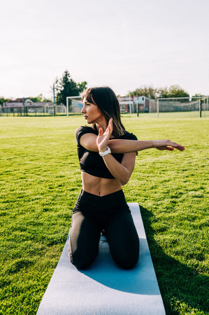 Young fitness girl doing stretching exercise outdoors on a sunny day. Fitness healthy lifestyle...