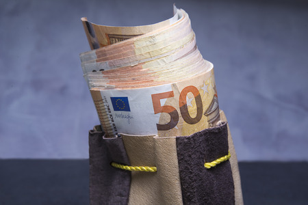 Closed up of fifty euros stuffed in the old pouchの写真素材