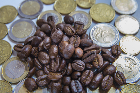 Roasted coffee beans with euro coins around itの写真素材