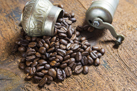 Roasted coffee beans spilled over the wood backgroundの写真素材
