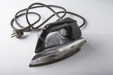 Old electric iron on the white background with the cordの写真素材