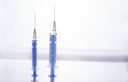 Two injections with needles stand up on white backgroundの写真素材