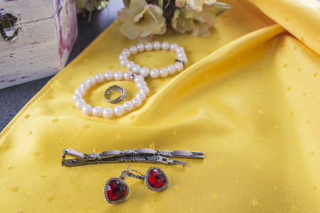 Bracelets and earings and ring on the yellow backgroundの写真素材