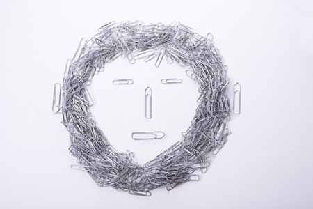 Face make from paper clips on white backgroundの写真素材