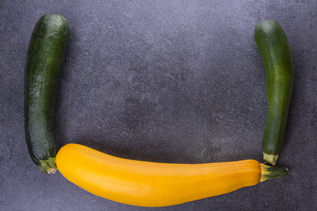 Three zucchini on the kitchen table, two green, one yellowの写真素材