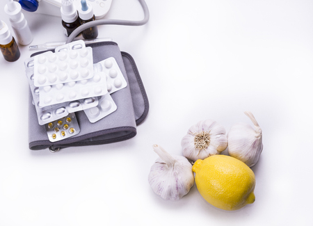Lemon and garlic versus druga and pills on the white backgroundの写真素材