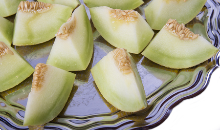 Closeup of fresh slices of yellow melon or cantaloupe on the old tray の写真素材