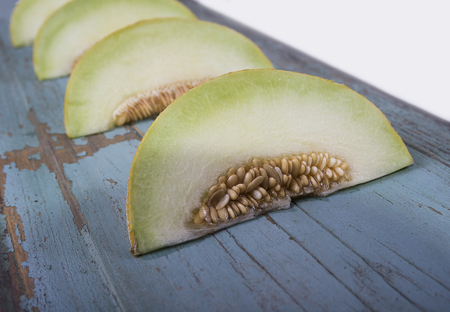 Fresh yellow melon or cantaloupe on old wooden boardの写真素材