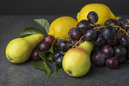 Fruit on the kitchen top like black grapes pears lemonの写真素材
