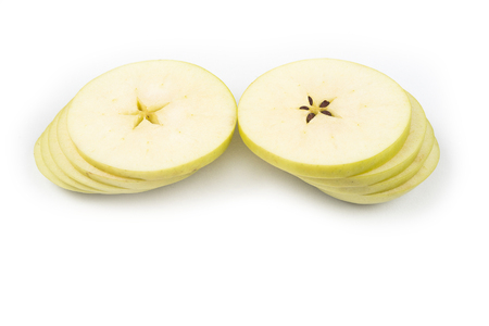 Apple cut on thin slices on each other on the white backgroundの写真素材