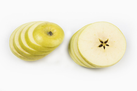Apple cut on thin slices on each other on the white backgroundの写真素材