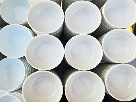 Stack of porcelain plates and bowls in restaurantの写真素材