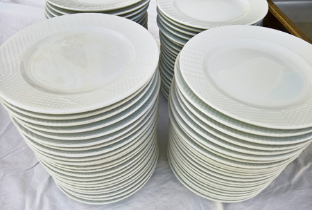 Stack of porcelain plates and bowls in restaurantの写真素材