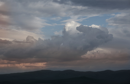 Dark dramatic landscape stormy sky over fieldの写真素材