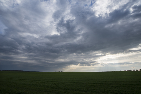 Dark dramatic landscape stormy sky over fieldの写真素材