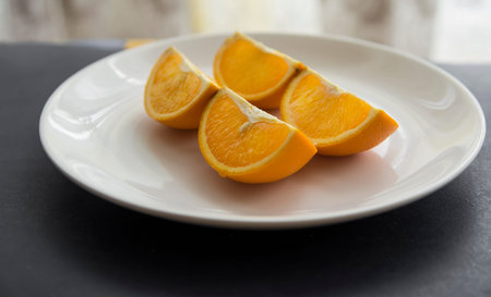 Orange cut in to slices on the white plate