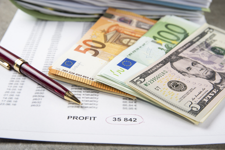 Profit and loss concept image of a pen, calculator and coins on financial documents.の写真素材