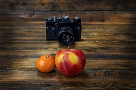 Film camera shoots mandarine and apple  on wooden backgroundの写真素材