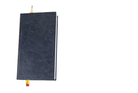 Closed notepad with pen or pencil on the white backgroundの写真素材