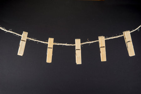 Clothes pin on the rope on the black background