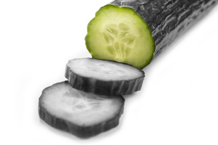 Cut cucumber with knife on the whiteの写真素材