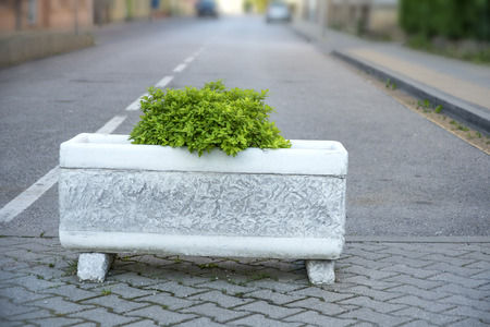 Concrete flowerpot at the end of the road in the townの写真素材