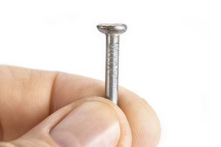 Man holding constraction nail on the whiteの写真素材