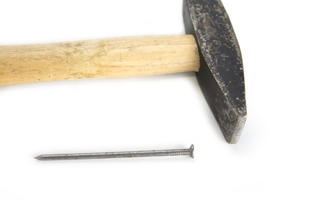 Used hammer with a nail on a white backgroundの写真素材